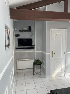 a hallway with a white door and a television at Nid Parisien in Cachan