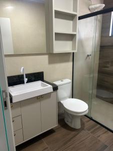 Un baño con inodoro, lavabo y ducha. en Pousada Ypê, en São Lourenço do Oeste