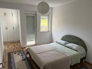 a bedroom with a bed and a window at Modern house near Center in Prishtinë