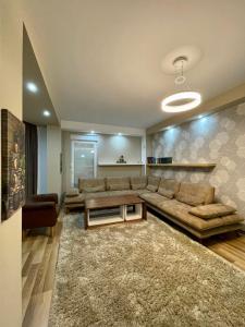a living room with a couch and a table at Modern house near Center in Prishtinë +1 photo