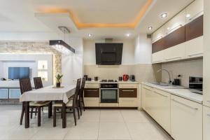 une cuisine avec une table et des chaises et une cuisine avec des armoires blanches dans l'établissement Urban Chic - One Bedroom Apartment -Luxury Warsaw Stays - Grzybowska 5, à Varsovie 4 autres photos