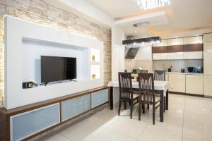 Il comprend une cuisine et une salle à manger avec une télévision murale à écran plat. dans l'établissement Urban Chic - One Bedroom Apartment -Luxury Warsaw Stays - Grzybowska 5, à Varsovie