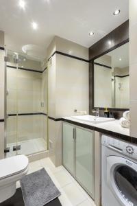 La salle de bains est pourvue d'un lave-linge et d'un sèche-linge. dans l'établissement Urban Chic - One Bedroom Apartment -Luxury Warsaw Stays - Grzybowska 5, à Varsovie