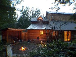 a log cabin with a fire in front of it at Almost Paradise Lodging in Ashford