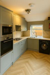 a kitchen with white cabinets and a sink and a dishwasher at Collin street in Nottingham
