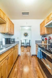 Una cocina con gabinetes de madera y una mesa con sillas. en Mins from the UofA & Downtown 4BR 2BA Entire Home, en Tucson