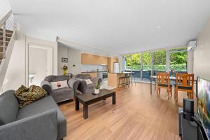 キャンベラにあるSpacious Apartment with Gym & Pool Accessのソファとテーブルのあるリビングルーム