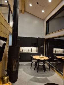 ルオストにあるDeluxe Luostoの暖炉、テーブル、椅子が備わる客室です。