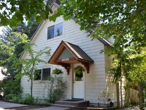 a white house with a sign that says inn at 1227 Haus in Leavenworth +4 photos