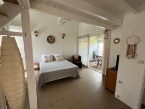 ein Schlafzimmer mit einem Bett und einem Fernseher darin in der Unterkunft Ti Valy in Saint-François