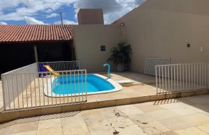 Una pequeña piscina en un patio al lado de una casa. en Charcara JJC, en Arapiraca