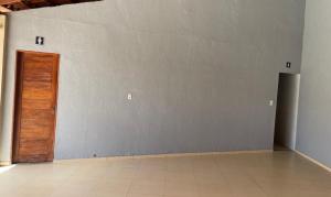 Habitación vacía con puerta y suelo de baldosa en Charcara JJC, en Arapiraca