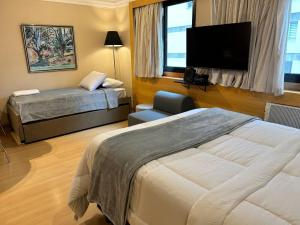um quarto de hotel com uma cama e uma TV de tela plana em TOP quarto Stay Inn hotel 3 min Av Paulista em São Paulo mais 94 fotografias