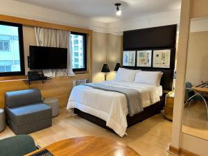 um quarto com uma cama, uma cadeira e uma televisão em TOP quarto Stay Inn hotel 3 min Av Paulista em São Paulo