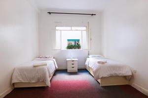 twee bedden in een kamer met een raam bij Iconic 2 Bedroom Apartment in Tanger