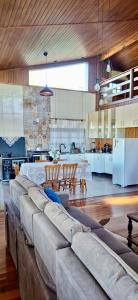 ein Wohnzimmer mit großer Couch und Küche in der Unterkunft Rancho Bela Vista - o seu recanto em Pelotas in Pelotas