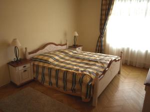 カルロヴィ・ヴァリにあるHalada house apartmentsのベッドルーム1室(ベッド1台、ナイトスタンド2台、窓付)
