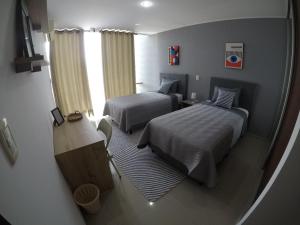 ein kleines Schlafzimmer mit zwei Betten und einem Fenster in der Unterkunft Serenity palmas in Santa Cruz de la Sierra