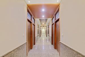a hallway of a building with wooden doors at Hotel O Royal Guest House in Ludhiana