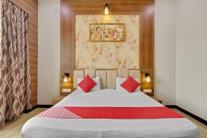 a bedroom with a large bed with red pillows at Hotel O Royal Guest House in Ludhiana