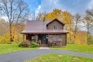 a log cabin with a metal roof on a driveway at Private Yard Secluded Hannibal Cabin in the Pines in Fulton
