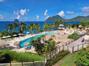 a resort with a swimming pool and the ocean at Le Blue Ground Vue Mer in Le Diamant