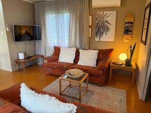 a living room with two couches and a tv at Country Cutie-Pie, close to town in Hastings