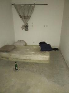 a bed in a room with a bottle on the floor at Warf in Brazzaville