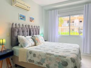 een slaapkamer met een groot bed en een raam bij Cond. Isola Ravenna - Ingleses Norte in Florianópolis +281 foto's