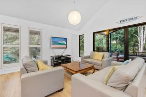 レインボー・ビーチにある43 Satinwood Drive Rainbow Shoresのソファ2つとテーブルのあるリビングルーム