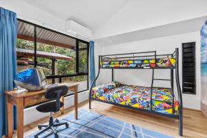 レインボー・ビーチにある43 Satinwood Drive Rainbow Shoresの机と二段ベッドのある寝室