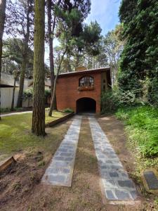 une maison avec une allée menant à un garage dans l'établissement El Remanso, à Mar de las Pampas