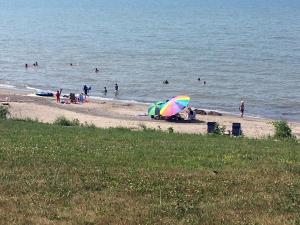 a group of people on a beach with an umbrella at Firefly Beach in Huron