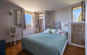 モントルーにあるGorgeous Home In Callianのベッドと椅子と2つの窓がある寝室