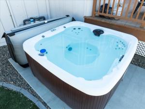 a jacuzzi tub sitting on a patio at Cedar Creek Lodge with POOL/hot tub/sleeps 24! in Oakhurst