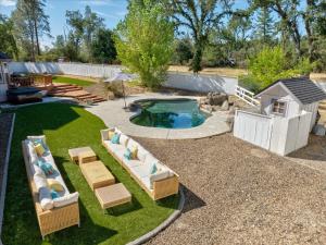 a backyard with a pool with chairs and a swimming pool at Cedar Creek Lodge with POOL/hot tub/sleeps 24! in Oakhurst