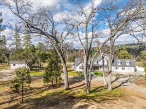 an aerial view of a house with trees at Cedar Creek Lodge with POOL/hot tub/sleeps 24! in Oakhurst