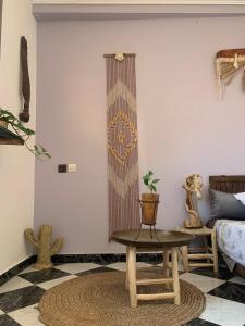 a living room with a table and a bed at The Flow Host in Tamraght Ouzdar