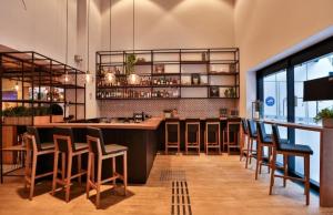 a bar in a restaurant with chairs and a counter at CONFORT iNN JARDINS in São Paulo
