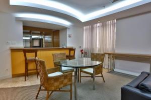 a living room with a glass table and chairs at CONFORT iNN JARDINS in São Paulo