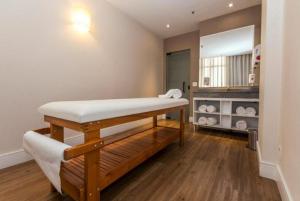 a room with a bench and a table in a room at CONFORT iNN JARDINS in São Paulo +29 photos