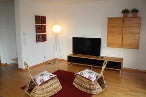 a living room with two chairs and a flat screen tv at Ferienhaus Sonnenhaus in Bodman-Ludwigshafen +15 photos