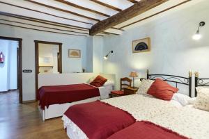 a bedroom with two beds with red sheets at La Casa De La Abuela Clotilde in Hornos