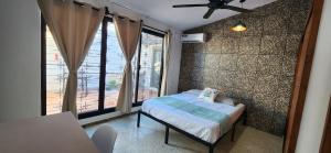 - une petite chambre avec un lit et une grande fenêtre dans l'établissement Loft Colibrí, à Ciudad del Carmen