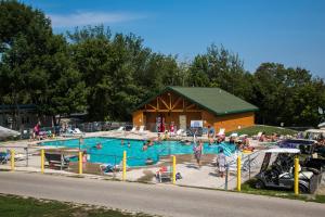a large swimming pool with people in it at Plymouth Rock Camping Resort One-Bedroom Cabin 6 in Elkhart Lake