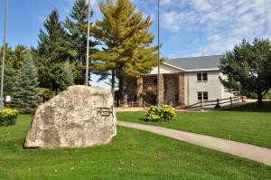 a large rock sitting in the grass in front of a building at Plymouth Rock Camping Resort Park Model 21 in Elkhart Lake