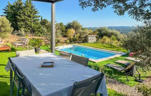 a table and chairs in a yard with a swimming pool at Awesome Home In Fayence in Fayence
