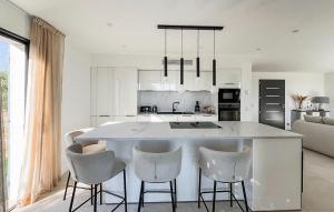 a kitchen with a large island with chairs around it at Awesome Home In Fayence in Fayence