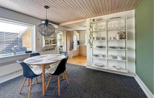 a kitchen and dining room with a table and chairs at 2 Bedroom Gorgeous Home In Østermarie in Østermarie