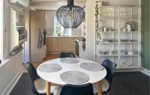 a dining room with a white table and chairs at 2 Bedroom Gorgeous Home In Østermarie in Østermarie